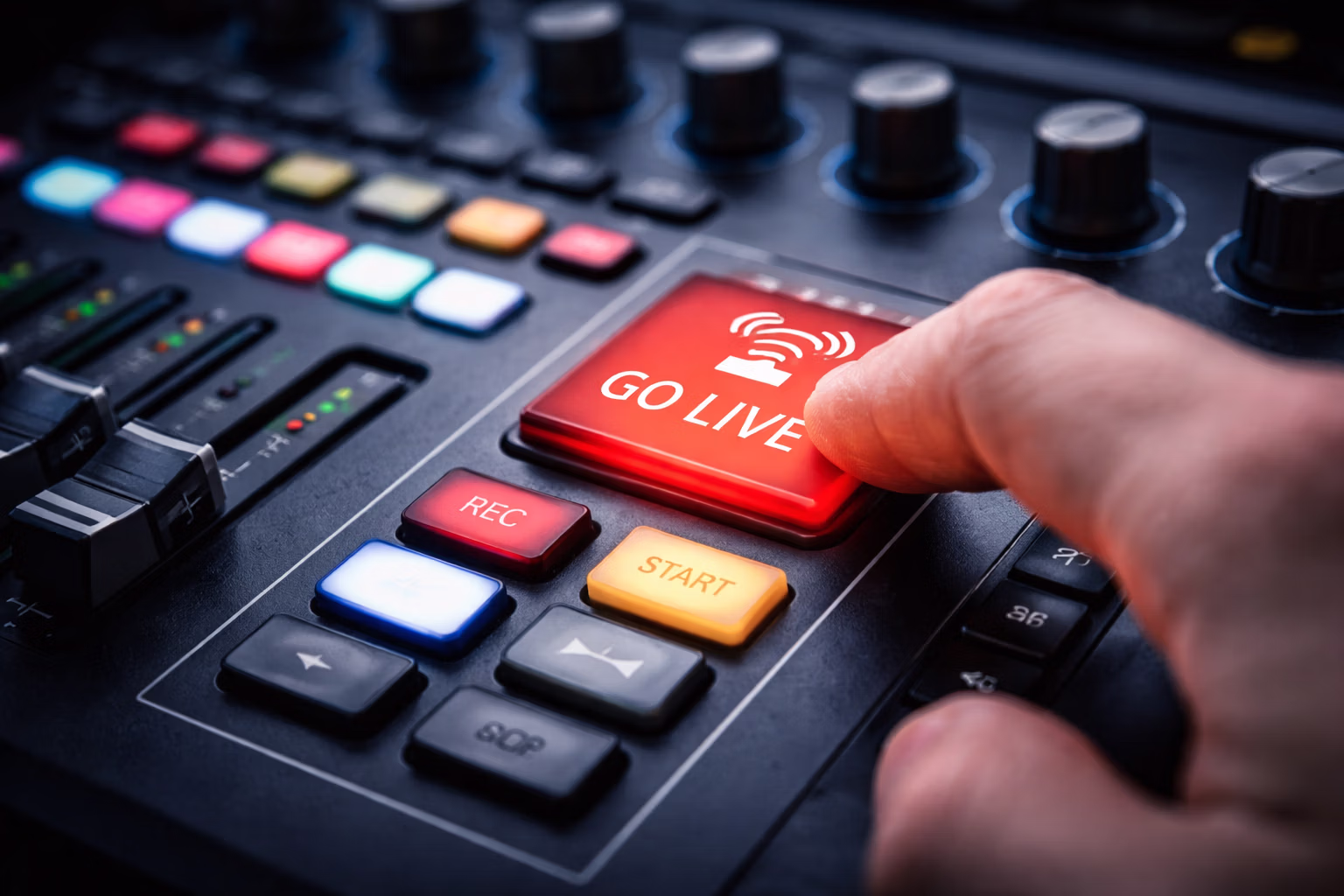 GoLiveButton Bild welches eine Hand Zeigt, die auf einem Mischpult auf den Button "Go Live" drückt. Fokus liegt auf der Hand und dem Button.